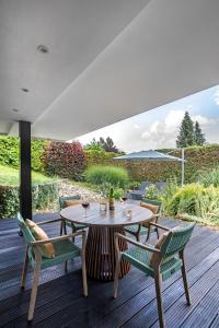 a patio with a table and chairs on a deck at PRIMERA am See in Gaienhofen