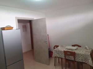 een kleine keuken met een tafel en een koelkast bij casa vacanza Nonna Lina in Rosolini