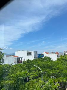 a group of white buildings on a hill with trees at THAI BINH MOTEL in Danang