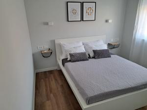 1 dormitorio blanco con 1 cama con 2 almohadas en B & R Summer breeze apartments, en Nin