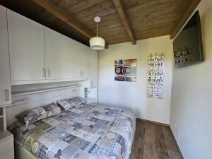 1 dormitorio con cama y techo de madera en Moda Apartments 01 en Sestriere