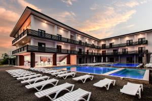 a resort with a swimming pool and lounge chairs at AMBASSADOR in Solotvyno
