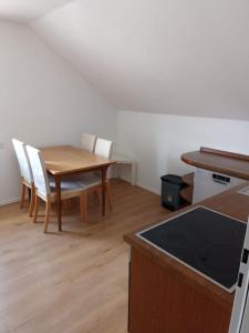a kitchen with a wooden table and white chairs at Ferienwohnung - Mitten in Lauf - 2 Zimmer, große Küche in Lauf an der Pegnitz