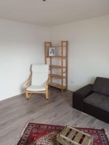 a living room with a couch and a chair at Ferienwohnung - Mitten in Lauf - 2 Zimmer, große Küche in Lauf an der Pegnitz