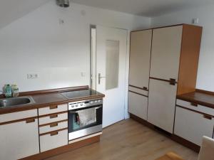 a kitchen with a stove and a sink and a refrigerator at Ferienwohnung - Mitten in Lauf - 2 Zimmer, große Küche in Lauf an der Pegnitz