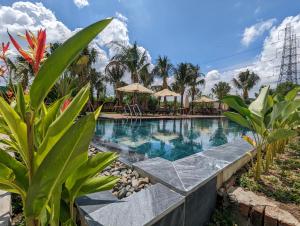 a swimming pool in a resort with palm trees at Minh Hai Resort in Phú Mỹ