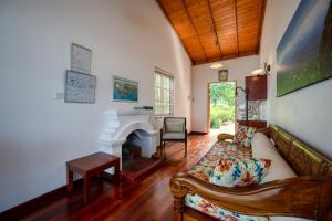 a living room with a couch and a fireplace at Kelburne Estate in Haputale
