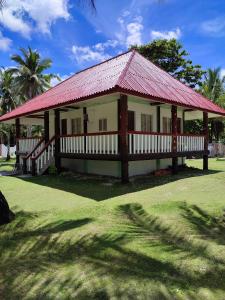 a small building with a red roof on a grass field at Capul Beach Resort in Capul