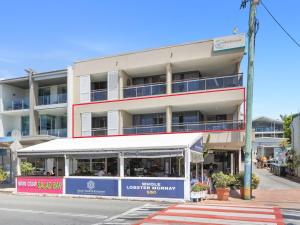 an apartment building with a white awning on a street at Beached On Marine Parade in Kingscliff