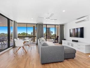 a living room with a couch and a table with chairs at Beached On Marine Parade in Kingscliff