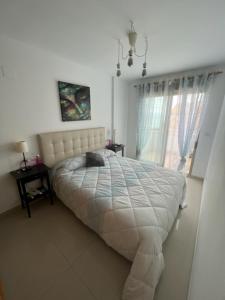 a bedroom with a white bed and a window at Sublime appartement vue Mer avec Piscine in El Campello +15 photos