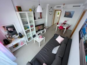 a living room with a black couch and a table at Sublime appartement vue Mer avec Piscine in El Campello