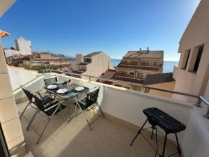 a patio with a table and chairs on a balcony at Sublime appartement vue Mer avec Piscine in El Campello