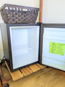an empty refrigerator with its door open on a floor at B&BHOUSE FAM in Ichinomiya