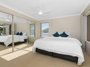 a bedroom with two beds and a large mirror at Beachfront On Marine in Kingscliff