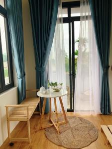 a table and a chair in a room with a window at Casablanca Hotel in Hue