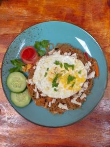 a blue plate of food with eggs on top at Hub Tata Guesthouse in Tuk Tuk