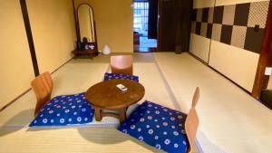 a room with a table and chairs with blue pillows at Guesthouse Kioto in Kyoto