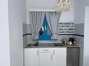 una cucina con lavandino e finestra blu di GIAVASI SEASIDE FINIKI a Foiníkion