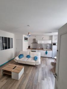 un soggiorno con un divano bianco e una cucina di Bienvenue à la plage ! ad Argelès-sur-Mer