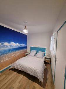 een slaapkamer met een bed en een schilderij van de oceaan bij Bienvenue à la plage ! in Argelès-sur-Mer