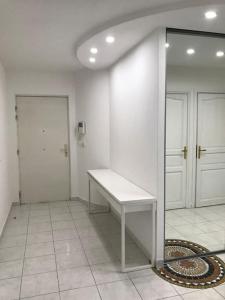 une chambre blanche avec un banc et une porte dans l'établissement Appartement 100 m2 hyper centre Saint-Raphaël, à Saint-Raphaël
