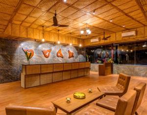 eine Lobby mit einem Tisch und Stühlen sowie eine Wand mit einem Gemälde in der Unterkunft The Estate Resort , Mangalore in Mūdbidri