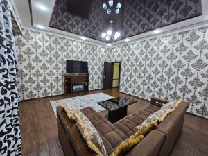 a living room with a couch and a tv at Новая 3-х комнатная квартира Мечта in Bukhara