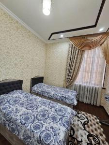 1 dormitorio con 2 camas y ventana en Новая 3-х комнатная квартира Мечта, en Bukhara