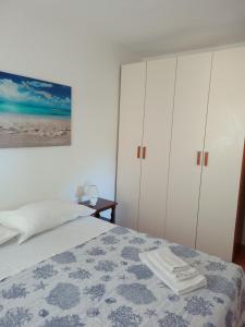 1 dormitorio con 1 cama y armarios blancos en Casa S'Ozastro, en Marinella