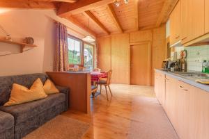eine Küche und ein Wohnzimmer mit einem Sofa und einem Tisch in der Unterkunft Bad Bergfallerhof in Olang