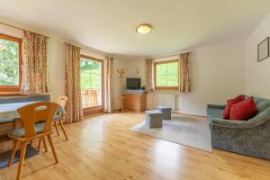 a living room with a table and a couch at Bad Bergfallerhof in Valdaora