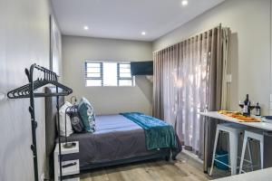 a small bedroom with a bed and a desk at 21 on Cathcart in Port Elizabeth