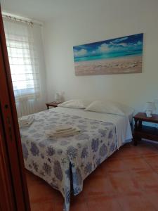 1 dormitorio con 1 cama y una pintura en la pared en Casa S'Ozastro, en Marinella