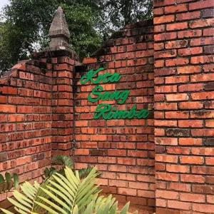 a brick wall with a sign on top of it at Inap Kota sang rimba in Kuala Terengganu