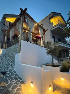 uma villa com uma escada que leva a uma casa em Trizonia Mare Suites em Trizonia