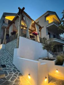 a villa with a staircase leading to a house at Trizonia Mare Suites in Trizonía