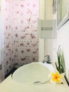 a bathroom with a sink and a flower on a counter at Apaula Heights Lounge in Apia