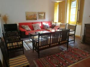 a living room with a red couch and a table at QUINTA ARENlLLAS Palacete en una finca privada de 7 hectáreas de pinar in Navalperal de Pinares