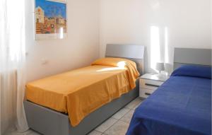 um quarto com uma cama com um cobertor amarelo em 3 Bedroom Lovely Apartment In Tortoreto Lido em Tortoreto Lido