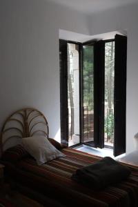a bedroom with a bed with a large window at QUINTA ARENlLLAS Palacete en una finca privada de 7 hectáreas de pinar in Navalperal de Pinares