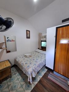 a small bedroom with a bed and a wooden door at Blessed Inn in San Miguel
