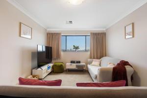 sala de estar con sofá y TV en 14 Excelsior Pde - BYO Linen - Pets Negotiable - Waterviews, en Hindmarsh Island