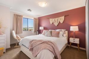 1 dormitorio con cama blanca y pared morada en 14 Excelsior Pde - BYO Linen - Pets Negotiable - Waterviews, en Hindmarsh Island