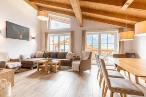 a living room with a table and a couch at Tauernlodges Uttendorf by ALPS RESORTS in Uttendorf