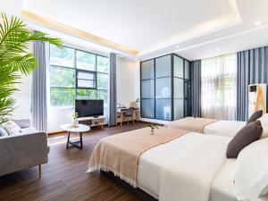 a hotel room with two beds and a tv at Beihai Silver Beach Yintai Time Seaview Villa Hotel in Beihai