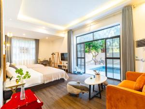 une chambre d'hôtel avec un grand lit et un salon dans l'établissement Beihai Silver Beach Yintai Time Seaview Villa Hotel, à Beihai