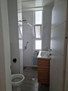 een badkamer met een toilet, een wastafel en een raam bij Abi's perfect place in Jeruzalem