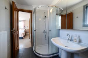 a bathroom with a glass shower and a sink at Panoramic View Kea in Péra Meriá