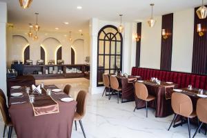 um restaurante com mesas e cadeiras e um balcão em ROYALE LALAWI HOTEL em Āīzawl